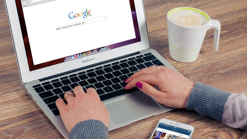 Hands typing on MacBook Air with Google search open, coffee nearby. - Hands typing on MacBook Air with Google search open, coffee nearby., tags: ai - pexel