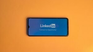 Smartphone showing LinkedIn login on vibrant orange background, symbolizing connectivity., tags: b2b saas - pexel