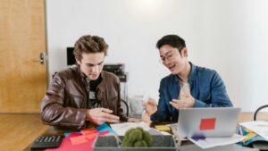 Two business professionals discuss ideas and strategies in an office setting, fostering innovation and teamwork., tags: fintech ppc drive lead - pexel