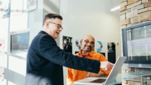 Two businessmen having a lively discussion in a modern office setting, pointing at a laptop screen., tags: saas - pexel