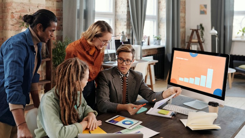 A group of diverse professionals discussing digital marketing plans in a modern office setting., tags: paid ads - pexel
