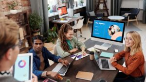 Team of diverse colleagues collaborating on project in modern office with digital devices and charts., tags: google ads - pexel