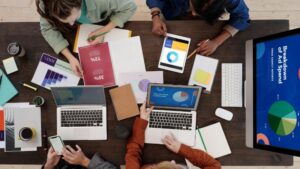 A diverse team collaborating on digital marketing strategies at a desk, using laptops and tablets., tags: paid ads - pexel