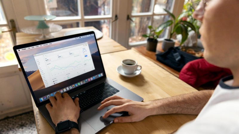 A person working on a laptop with business analytics displayed, showcasing a remote work setup in a cozy environment., tags: ads google - pexel